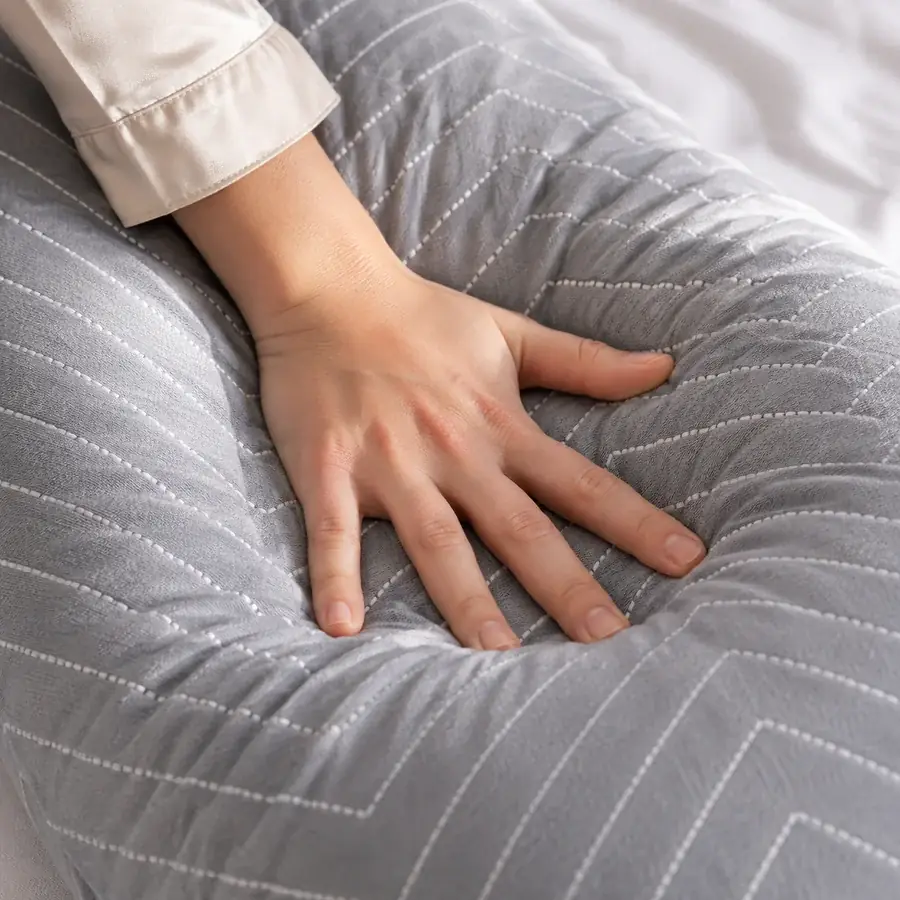 A palm pressing flat on the pillow’s arm, the fabric sinking under the pressure