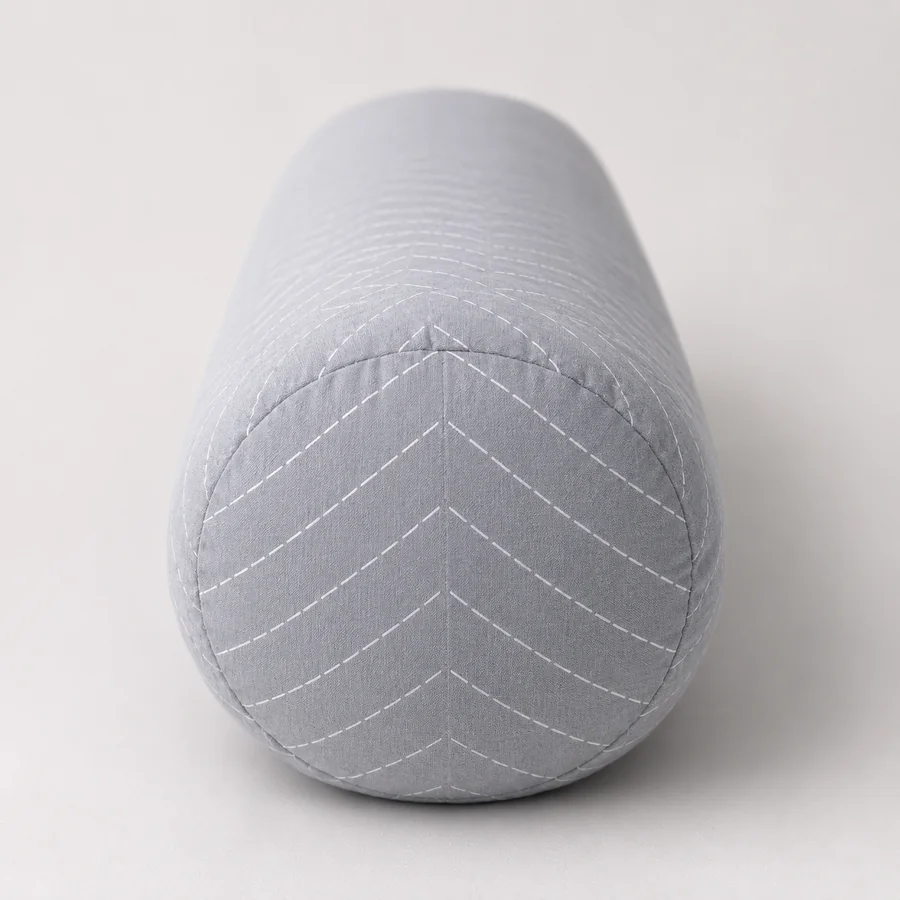 Pregnancy pillow seen end-on, the thickness of the bolster readable against a neutral background