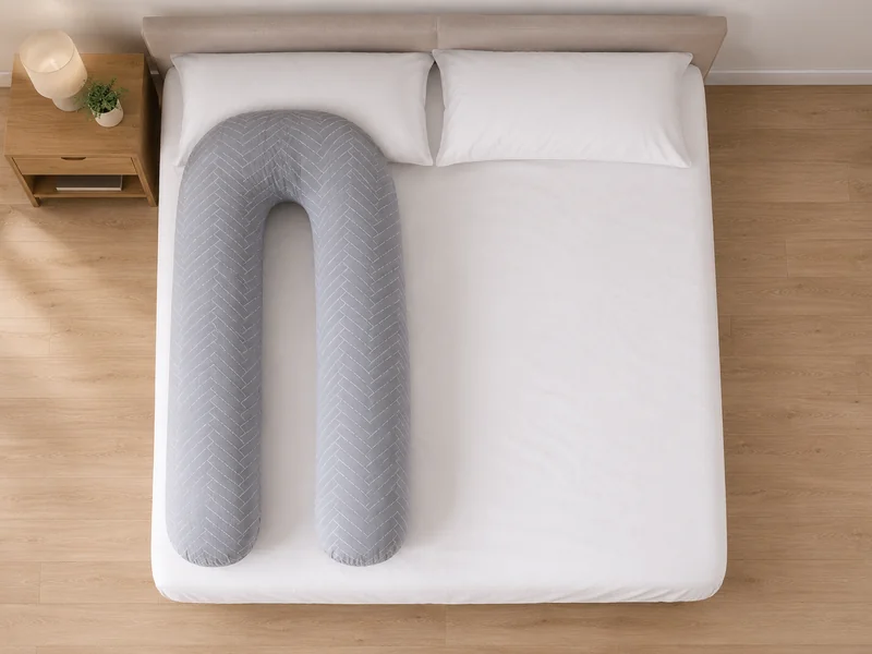 Double bed seen from above, the U-shaped pillow taking one side of the mattress